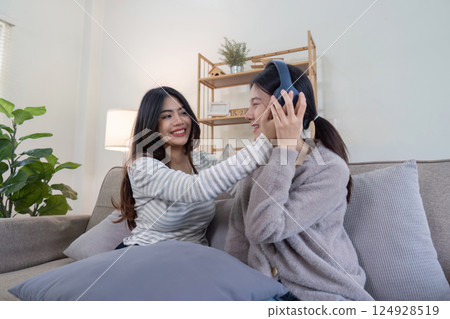Joyful lesbian couple enjoying music together at home intimate lifestyle moment cozy environment warm atmosphere Joyful lesbian couple enjoying music together at home intimate lifestyle moment cozy environment warm atmosphere 124928519