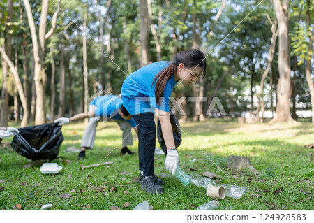 Family volunteers collect garbage in park community cleanup nature outdoor engaging in environmental action 124928583