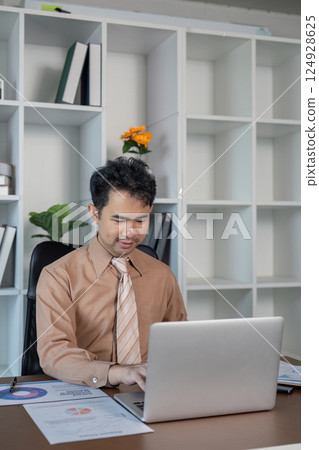 Business professional working on laptop in modern office environment business strategy indoor setting focused view 124928625