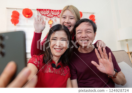 Chinese new year celebration family bonding with grandparents and granddaughter indoor setting heartwarming moments 124928724