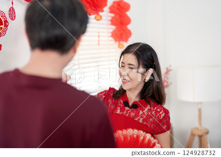 Elderly couple celebrating chinese new year at home embracing traditions in a joyful environment 124928732