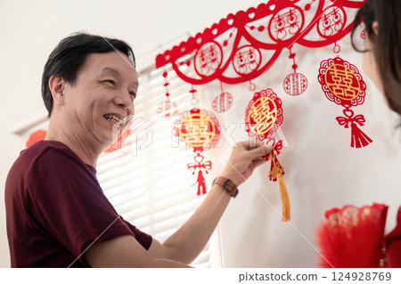 Elderly couple celebrating chinese new year decorations at home warm atmosphere intimate moment joyful tradition 124928769