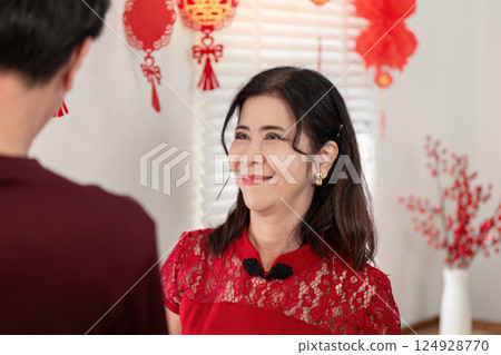 Elderly couple celebrating chinese new year at home joyful atmosphere festive decorations warm environment 124928770