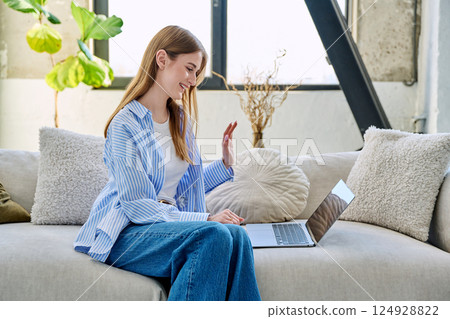 Young woman using laptop for video call, online chat conference sitting at home 124928822