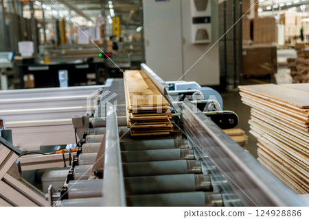 Production line of the wooden floor factory. CNC automatic woodworking machine. 124928886