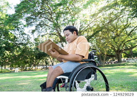 Young Artist in Wheelchair Drawing Outdoors in Sunny Park Surrounded by Lush Greenery and Trees Young Artist in Wheelchair Drawing Outdoors in Sunny Park Surrounded by Lush Greenery and Trees 124929029