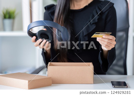 Woman purchasing headphones with credit card online Woman purchasing headphones with credit card online 124929281