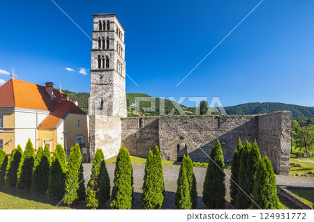 Jajce town in Bosnia and Herzegovina, Europe. Church of St. Mary with the tower of St. Luke. Ancient stone tower under a vibrant blue sky, surrounded by trees and a fortress wall. Jajce town in Bosnia and Herzegovina, Europe. Church of St. Mary with the tower of St. Luke. Ancient stone tower under a vibrant blue sky, surrounded by trees and a fortress wall. 124931772