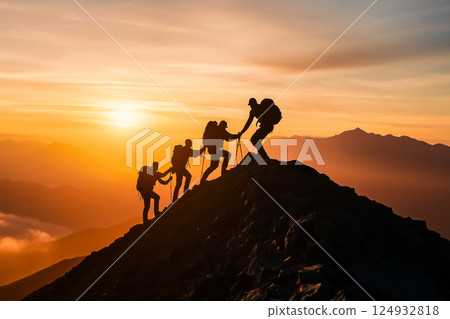 Group of climbers helping each other on a cliff 124932818