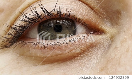 Focus on right green eye of attractive girl blinking and looking into camera. Portrait of upset female face. Sorrowful facial expression of young woman. Unhappy sight of beautiful lady. Close up 124932899
