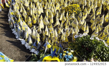 Many small flags of Ukraine with names of the dead war against russia. Memorial of the fallen soldiers, children, women in the center of Kyiv. Concept of tragedy and misfortune. Closeup 124932915