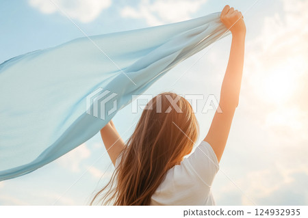 A moment of freedom, a girl waving a blue cloth 124932935