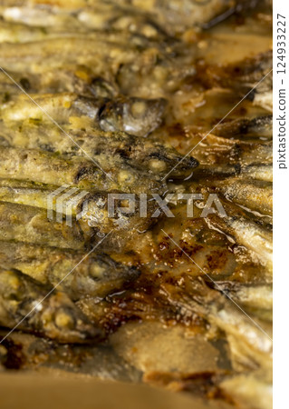 capelin fish fried in oil, stacked in rows cooked hot capelin baked in sunflower oil capelin fish fried in oil, stacked in rows cooked hot capelin baked in sunflower oil 124933227