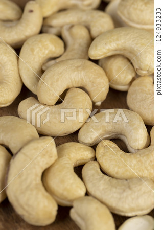 cashew are scattered on a board, cashew are healthy and allowed for vegans. close up 124933233