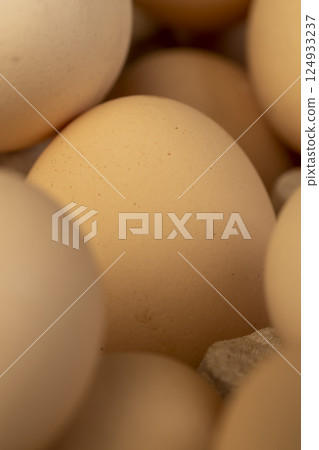 light eggs in paper packaging, fresh large chicken eggs during packaging, close up 124933237
