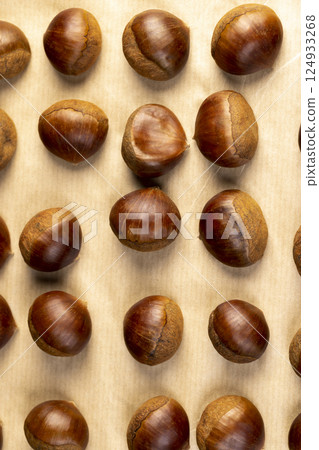 chestnut fruits for frying or baking , preparation by cutting the shells of edible chestnut nuts, top view chestnut fruits for frying or baking , preparation by cutting the shells of edible chestnut nuts, top view 124933268