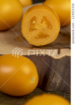 sliced ripe tomatoes on the board of their nut trunk , whole clean washed tomatoes are sliced for cooking, side view sliced ripe tomatoes on the board of their nut trunk , whole clean washed tomatoes are sliced for cooking, side view 124933330