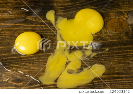 chicken egg on a black table, a broken cracked chicken egg , closeup 124933342
