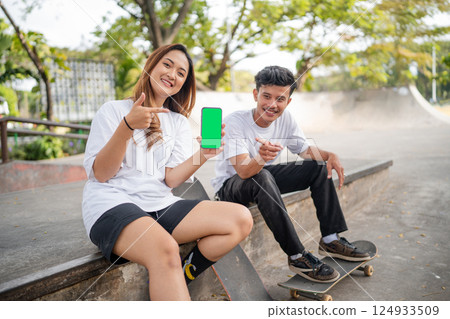 Young skateboarders are having fun on a sunny day at their local skate park 124933509
