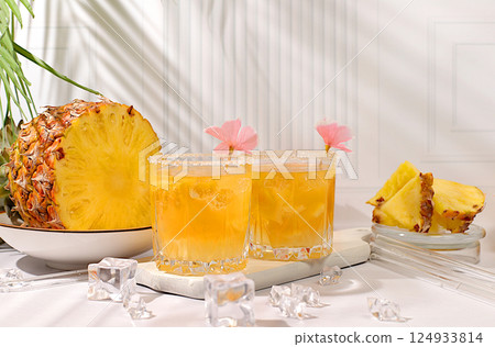 Refreshing summer diet drink recipe,Cold homemade cocktail or lemonade with pineapple, orange, ice on sunny kitchen modern table,Detox diet and summer party concept.restaurant menu, 124933814