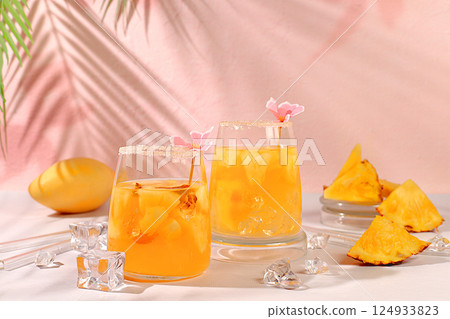 Refreshing summer diet drink recipe,Cold homemade cocktail or lemonade with pineapple, orange, ice on sunny kitchen table,Detox diet and summer party concept.restaurant menu,selective approach 124933823