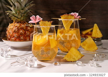 Homemade cocktail or lemonade with pineapple, orange, ice on sunny kitchen table. Refreshing summer diet drink recipe, Detox diet and summer party concept. Restaurant menu, selective approach 124933827