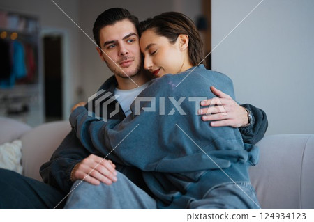 Couple embracing on a couch in a cozy indoor setting during the evening 124934123