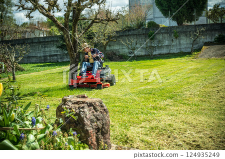 Man on riding lawn mower Man on riding lawn mower 124935249