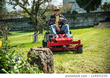 Man on riding lawn mower Man on riding lawn mower 124935250
