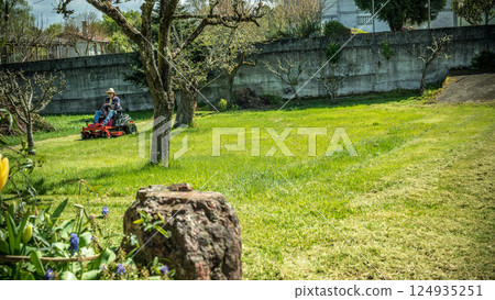 Man on riding lawn mower Man on riding lawn mower 124935251
