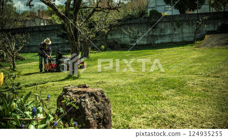 Man on riding lawn mower 124935255