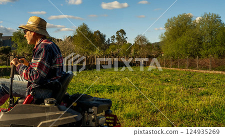 Man on riding lawn mower Man on riding lawn mower 124935269