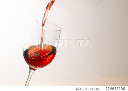 Pour the red wine into the glass 124935308