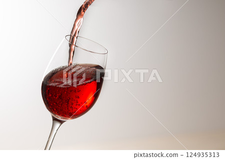 Pour the red wine into the glass 124935313