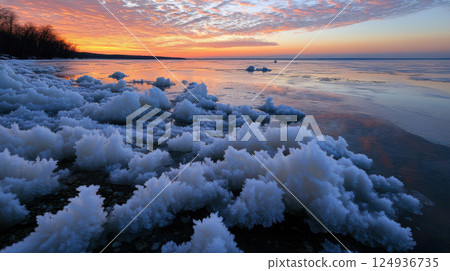 Frozen lake landscape with ice formations and colorful sunset sky Frozen lake landscape with ice formations and colorful sunset sky 124936735