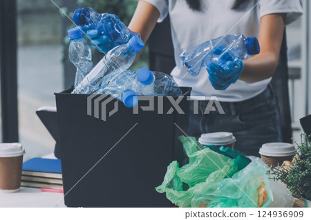 Close-up of female hands from a family collecting plastic waste and bottles from the ground. They wear gloves and focus on recycling to help reduce plastic pollution and protect the environment. Close-up of female hands from a family collecting plastic waste and bottles from the ground. They wear gloves and focus on recycling to help reduce plastic pollution and protect the environment. 124936909