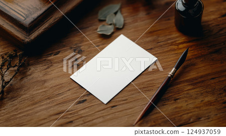 blank business card on wooden table with pen and leaves nearby 124937059