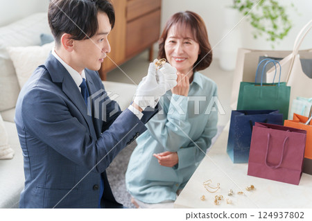 一位流動二手買家與一位女性顧客一起評估商品 124937802