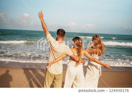 Happy Group of Friends Enjoying a Beach Party Under the Sun 124938176