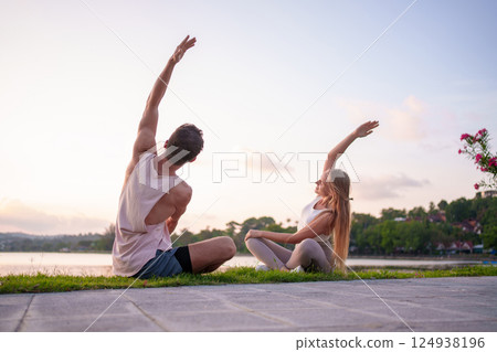 Couple Practicing Yoga by Tranquil Lakeside at Sunset for Wellness and Peace 124938196