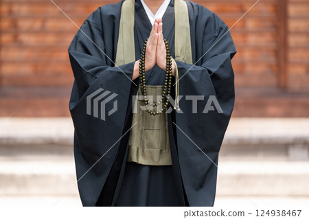 A monk praying with hands together 124938467