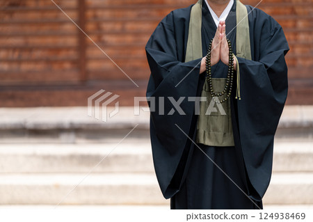A monk praying with hands together A monk praying with hands together 124938469