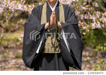 A monk praying with hands together 124938473