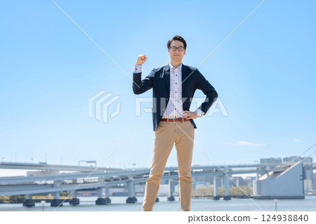 A man posing in a fist under the blue sky A man posing in a fist under the blue sky 124938840