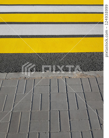 Freshly painted pedestrian crossing with yellow and white markings on asphalt, vertical photo, sunlight 124938999