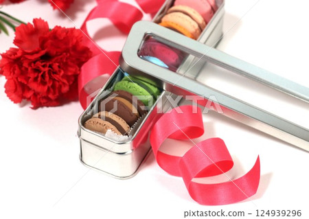 一個裝滿紅色康乃馨和彩色馬卡龍的錫盒 124939296