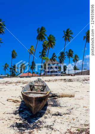 Old wooden boat ashore on tropical sandy Nungwi beach in the Indian ocean on Zanzibar, Tanzania Old wooden boat ashore on tropical sandy Nungwi beach in the Indian ocean on Zanzibar, Tanzania 124939696