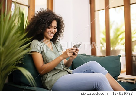 Joyful Young Latin Woman Engaging with Her Phone on a Home Sofa. Generative ai 124939788