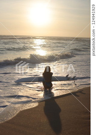 Surfing at Sunset A Beautiful and Serene Moment to Enjoy by the Oceans Edge, Embracing Nature 124941929