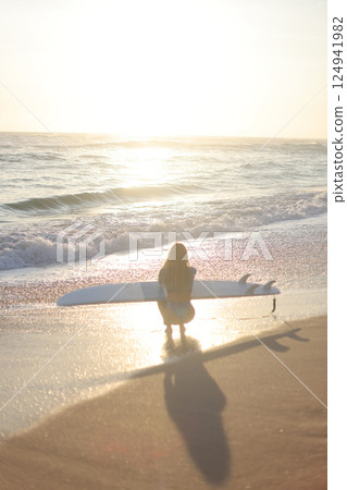 Surfing at Sunset A Beautiful and Serene Moment to Enjoy by the Oceans Edge, Embracing Nature 124941982